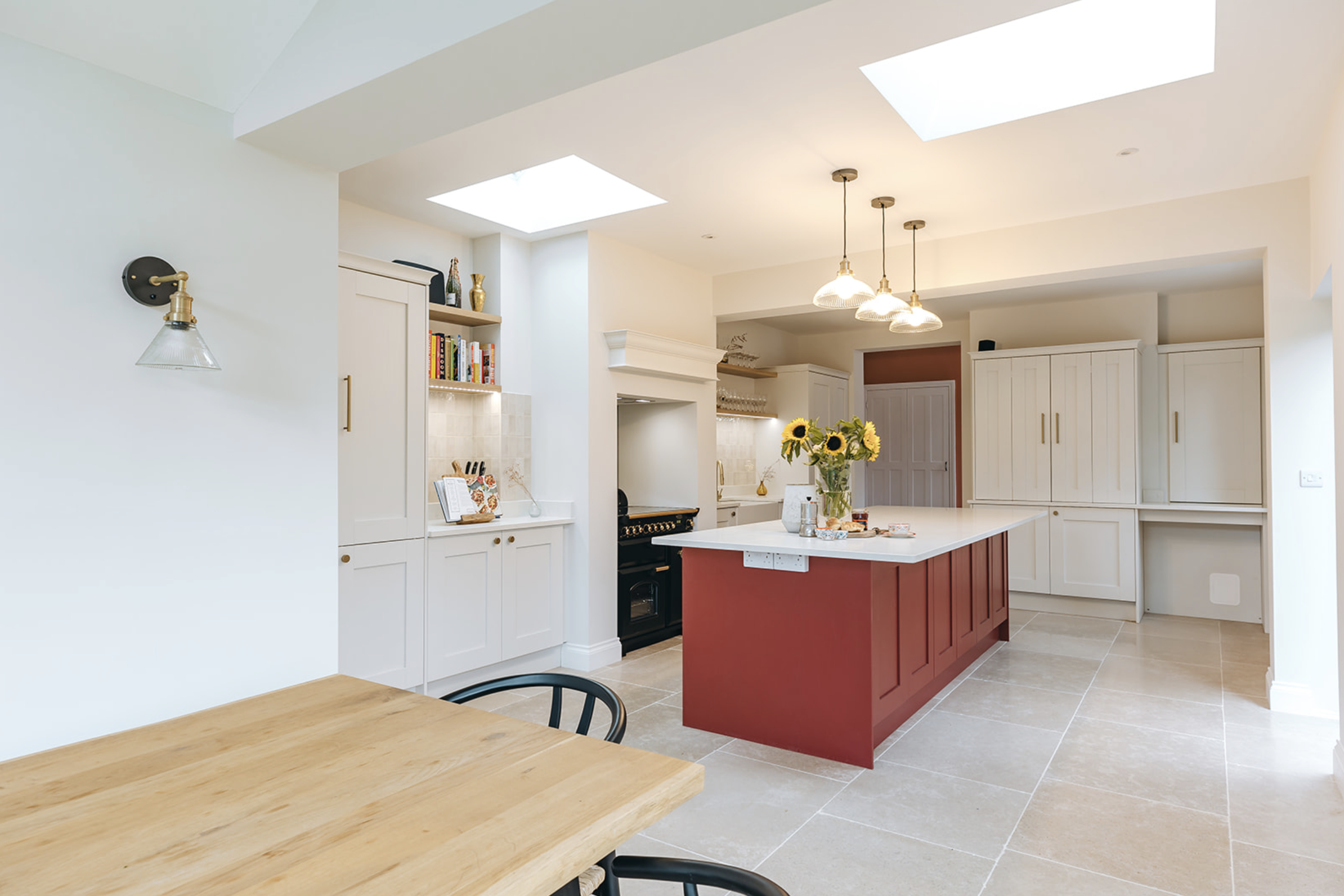 Remodelled kitchen with rust-red island in a period farmhouse