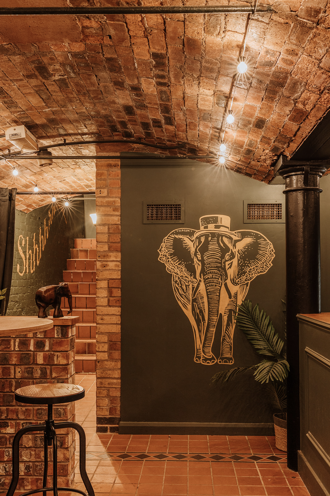 Gold elephant mural facing the tiled stair at The Underground, with the Shhh signage visible beyond