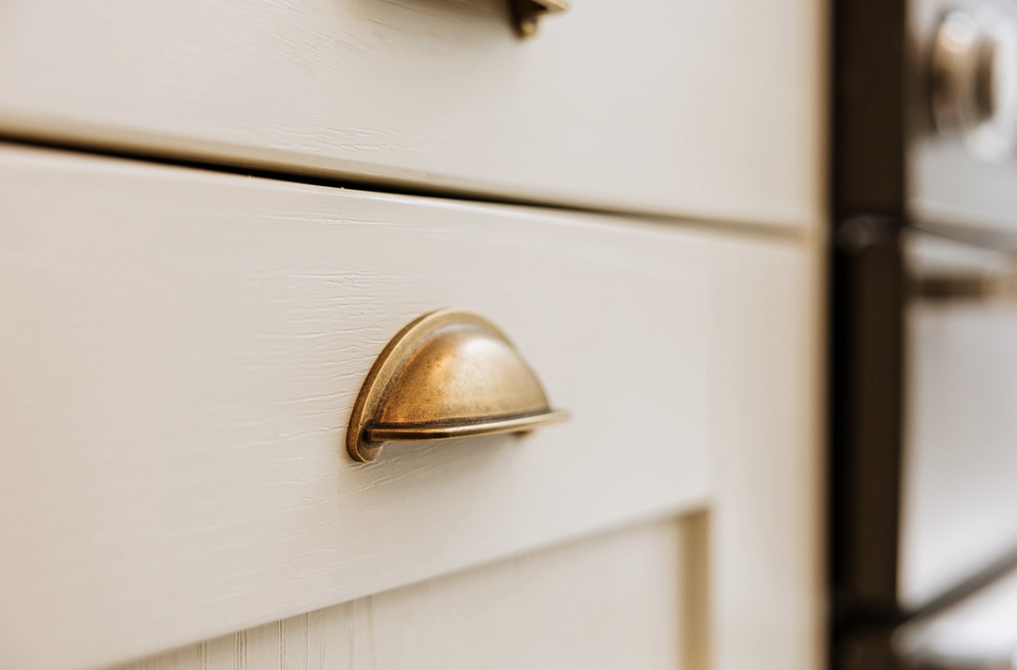 Antique brass cup handle on painted timber kitchen joinery