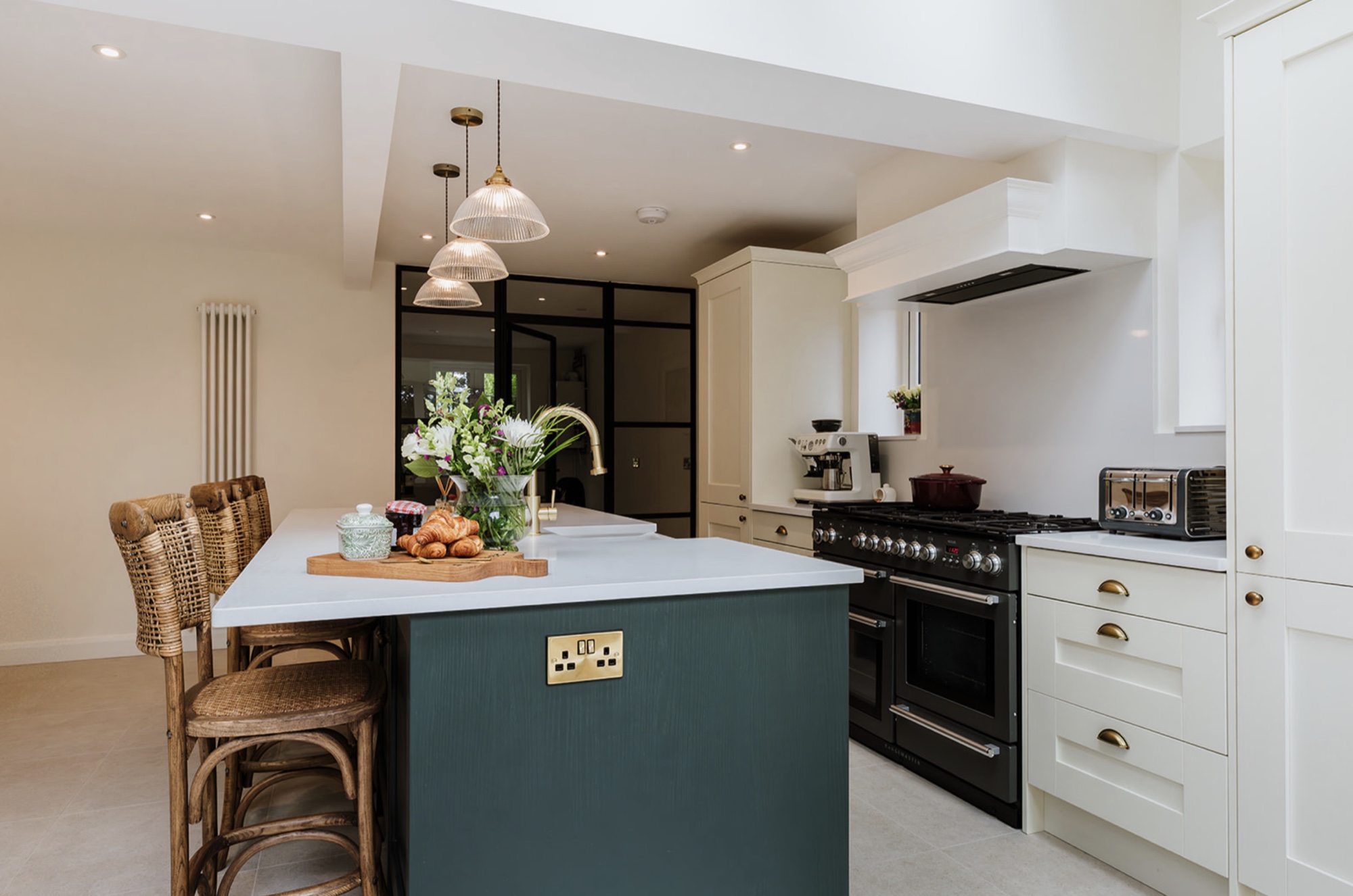 Fairholm's completed kitchen with a green island, pale cabinetry and glazed screen