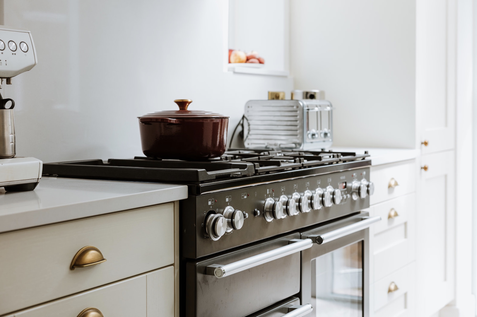 Close view of the black range cooker between painted timber cabinets